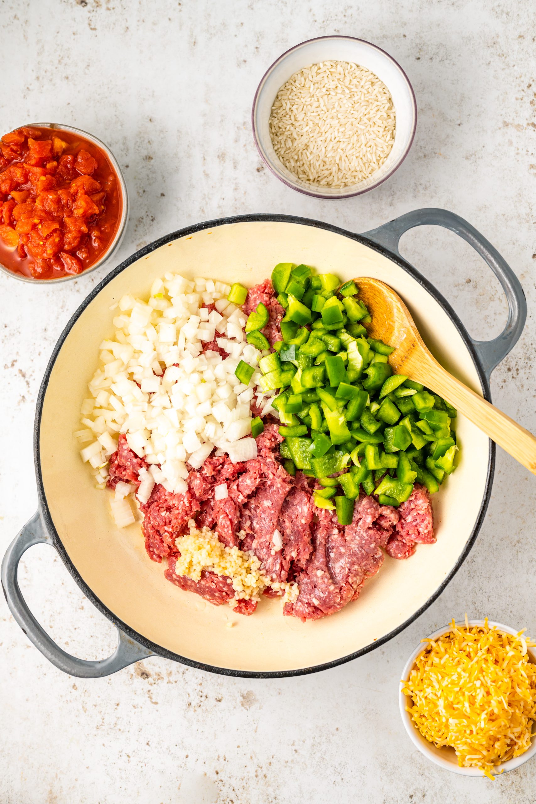 Ground beef and vegetables in a skillet on a white background.