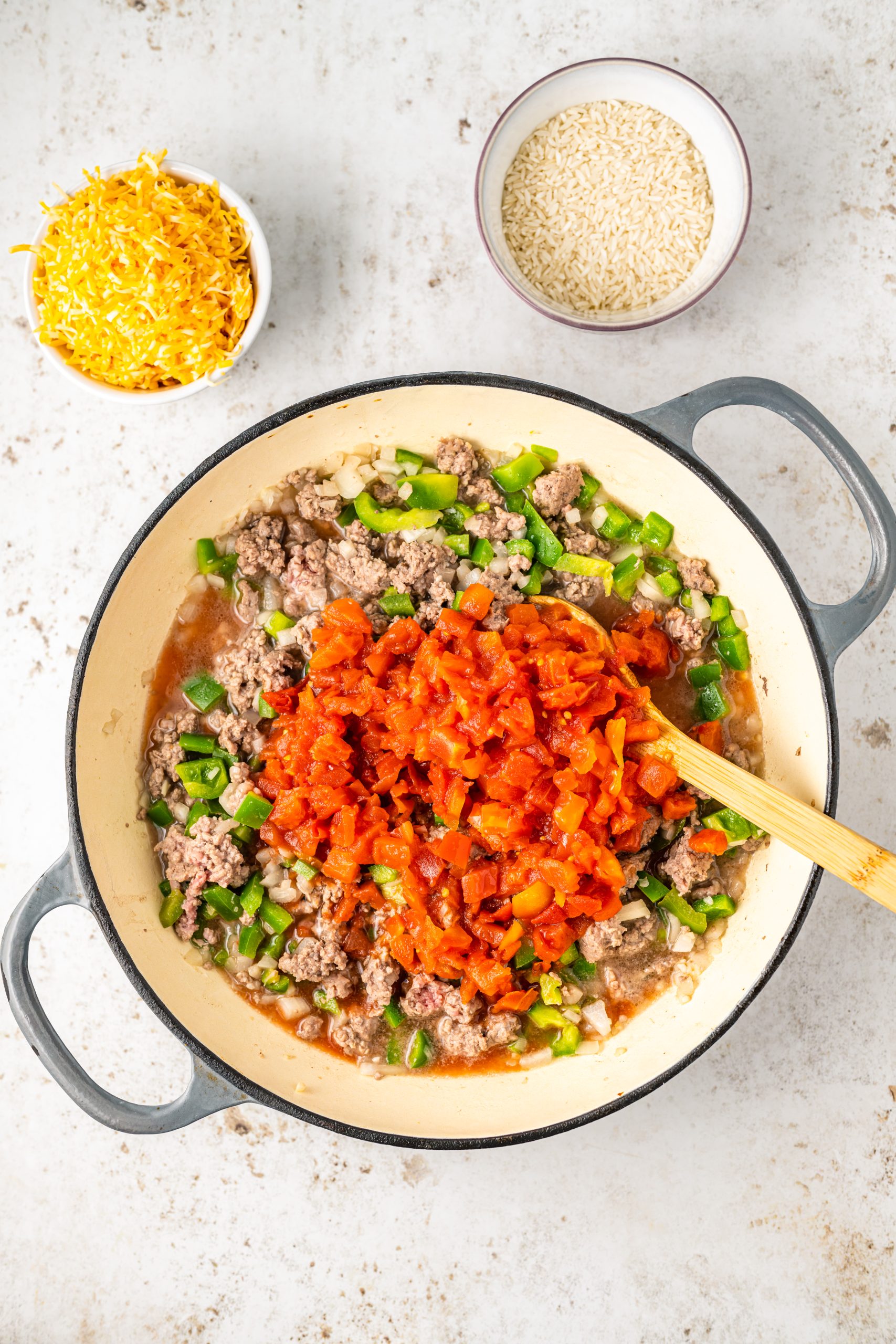 A skillet with cheddar beef and vegetables in it.