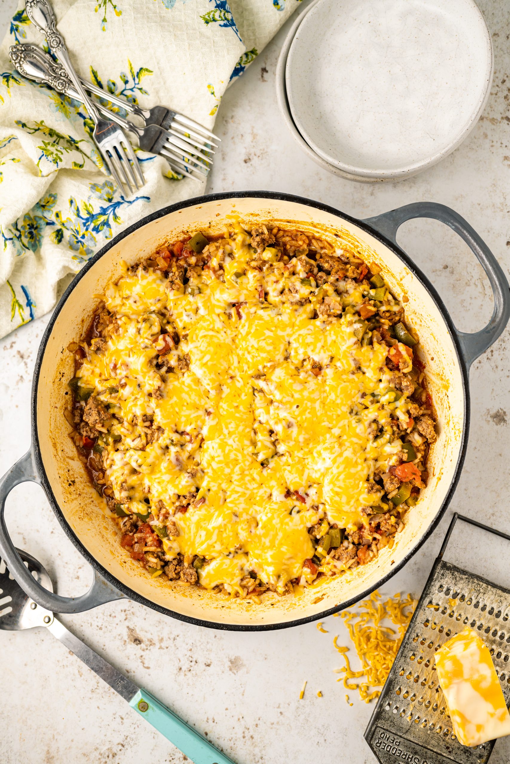 A Cheddar casserole dish with cheese on top of it.