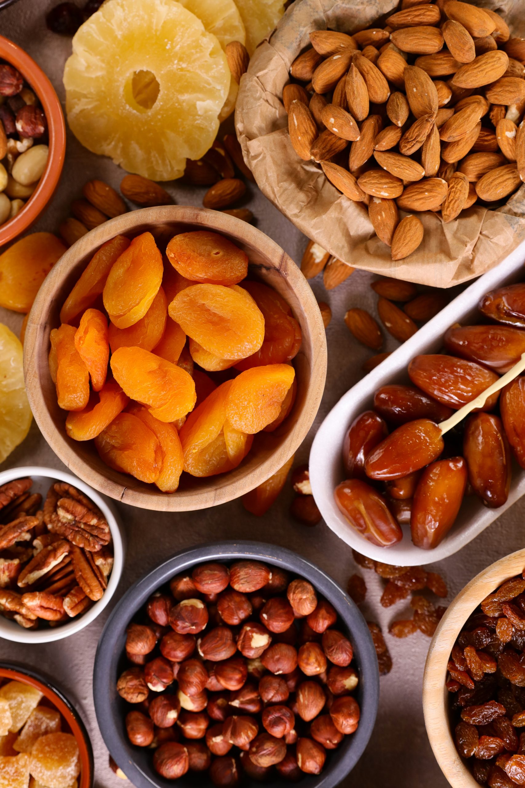 A variety of dried fruits and nuts in bowls.