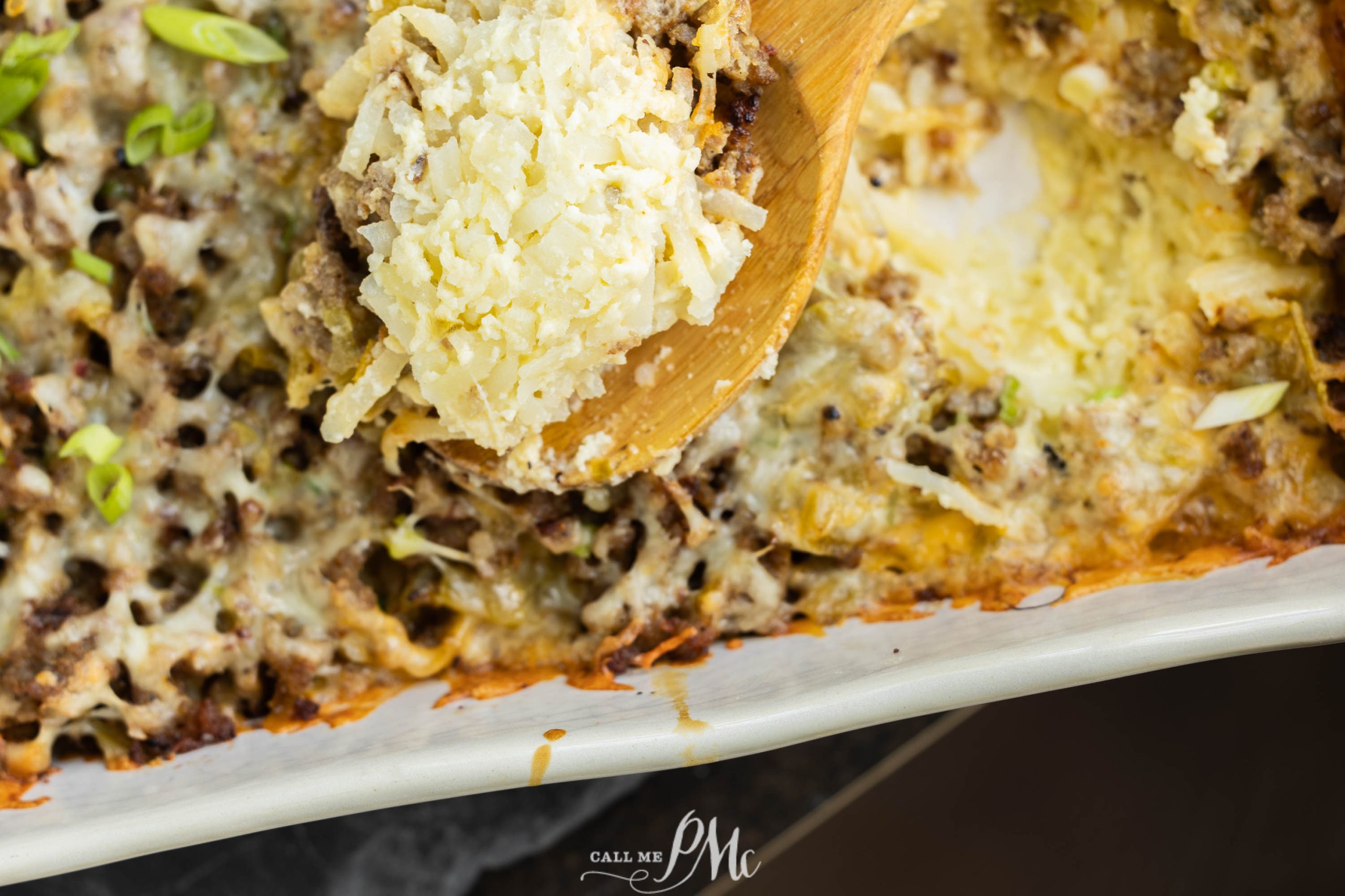 A Overnight Sausage Hash Brown Casserole with cheese and meat in it.
