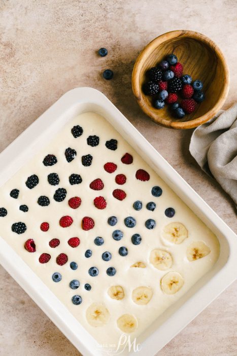 A white dish with berries and blueberries on it.