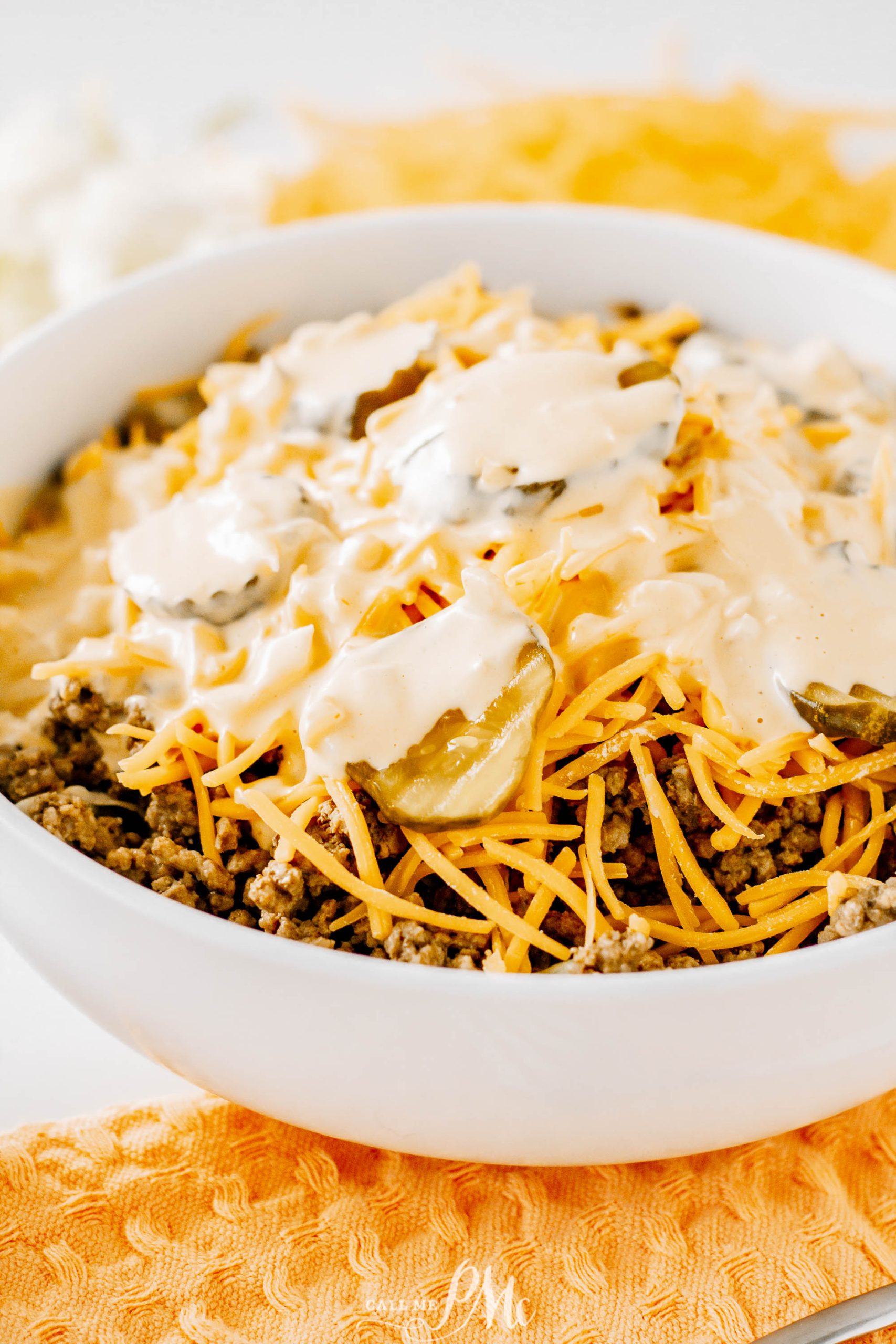 Cheesy nachos with cheese in a white bowl.
