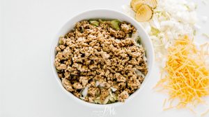 A bowl of ground beef, onions, and cheese.