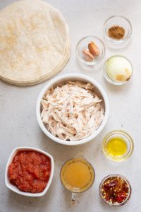 Ingredients for chicken tinga on a white table.