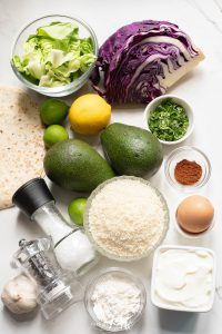 The ingredients for a quinoa salad are laid out on a table.