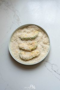 A plate with a bowl of fried zucchini on it.