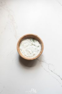 A bowl of tzatziki sauce on a marble table.