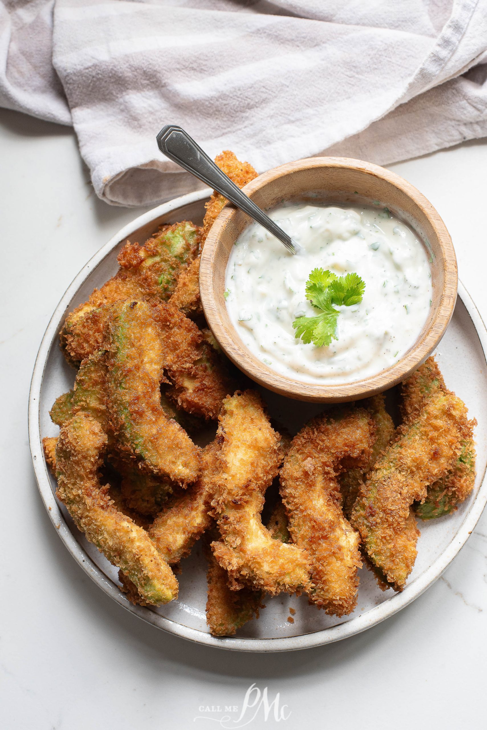 Fried okra with a dip on a plate.