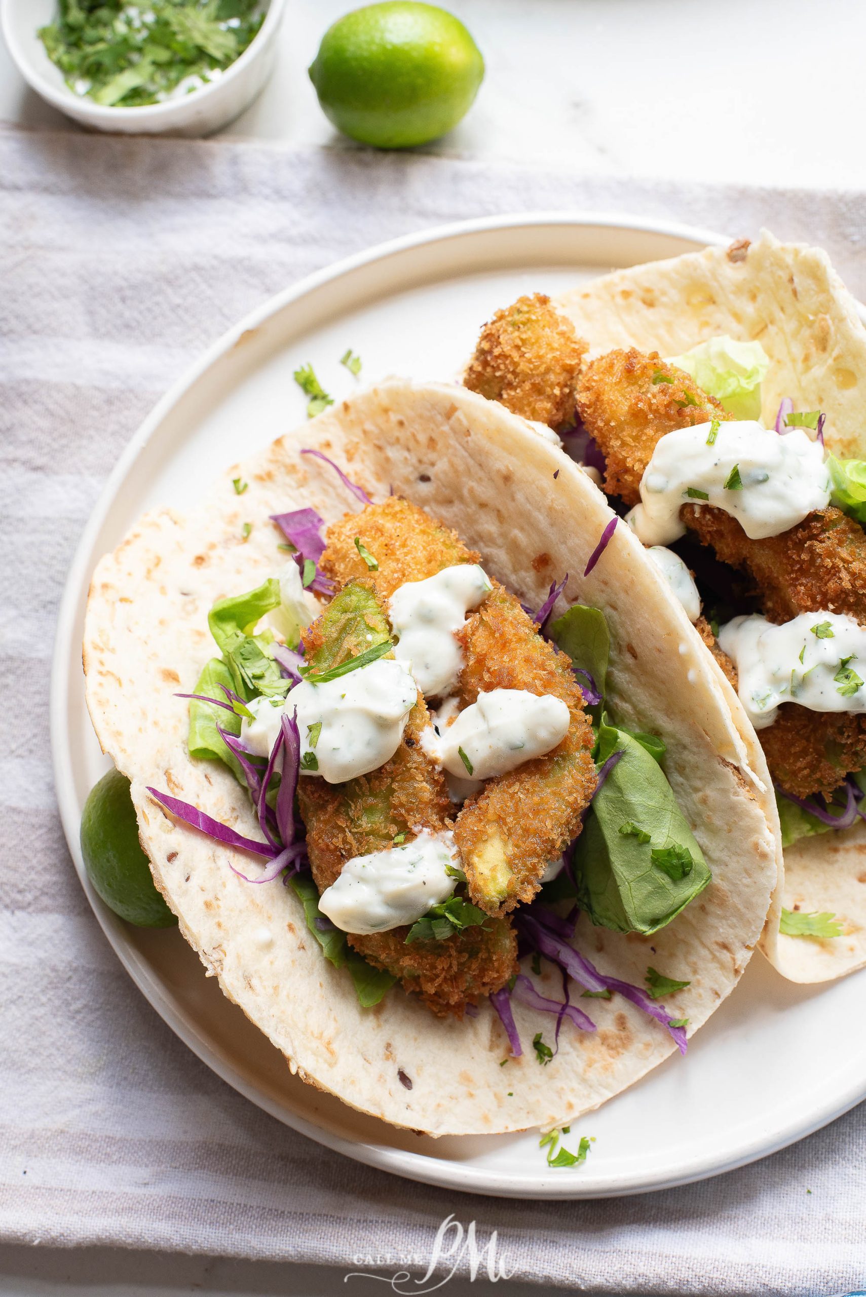 Two Oven-fried avocado tacos on a white plate.