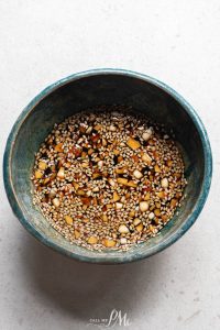 Sesame seeds in a bowl on a white surface.