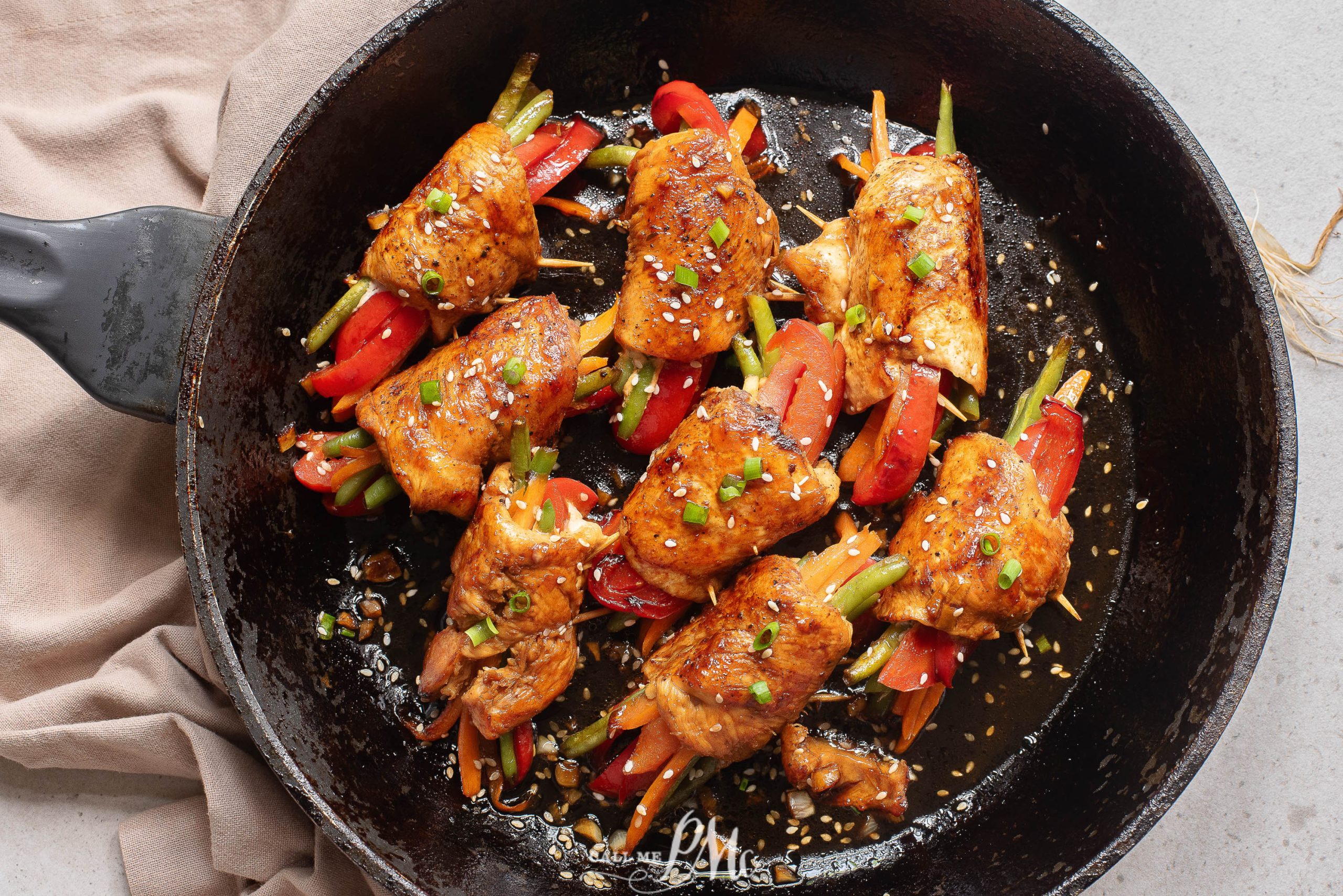 Vegetables wrapped in chicken cutlets in a skillet.