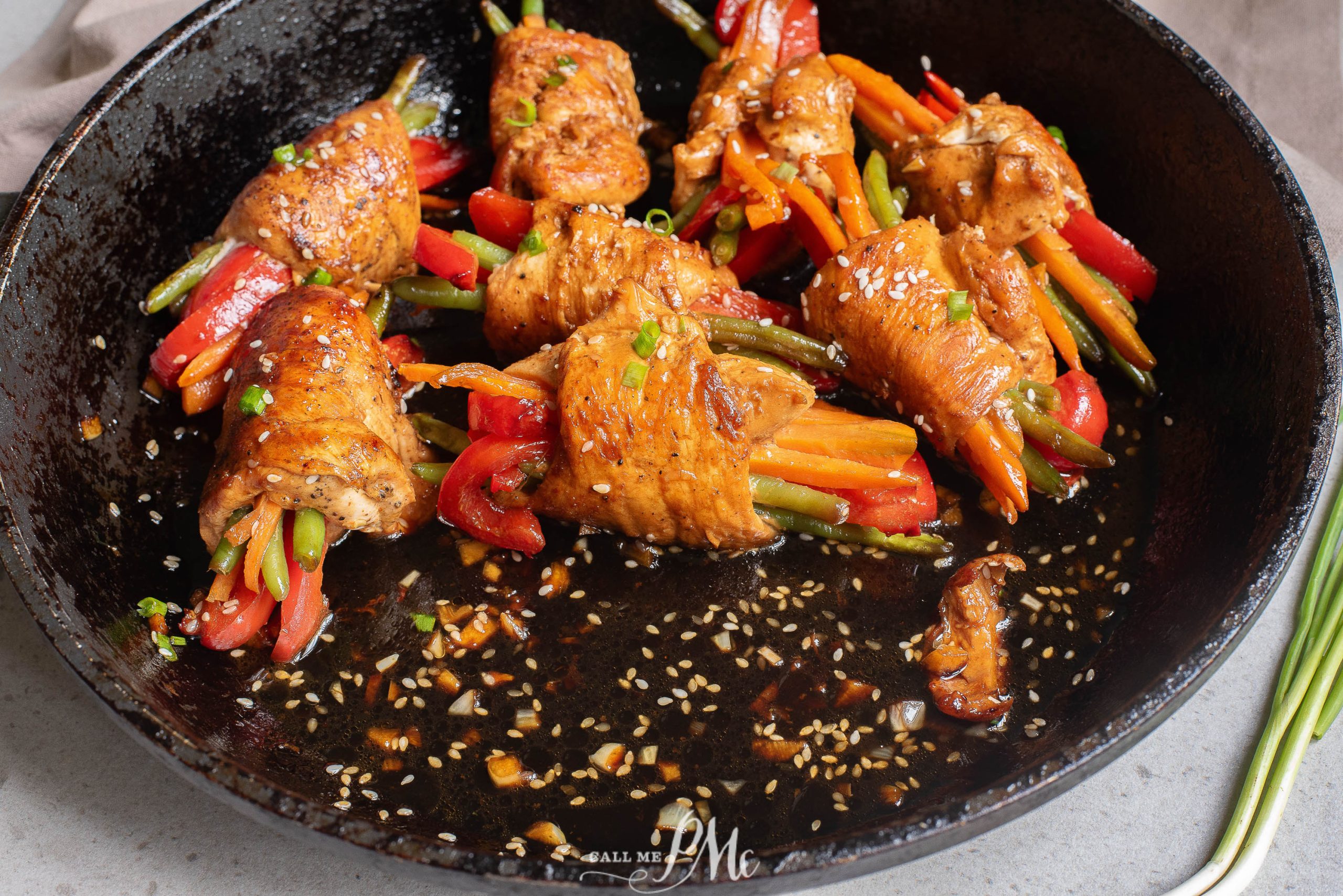 A frying pan with chicken and vegetables in it.