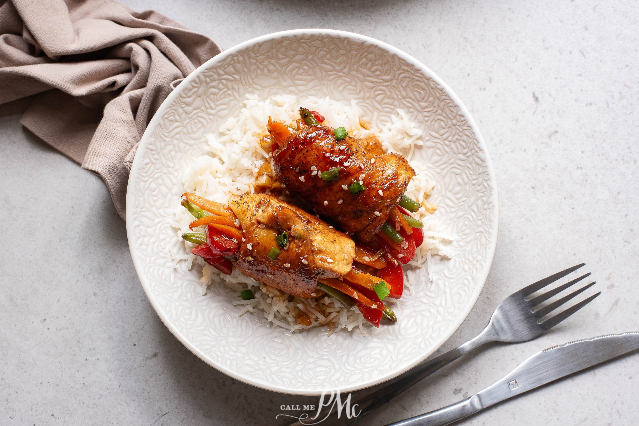 A white plate with chicken and vegetables on it.