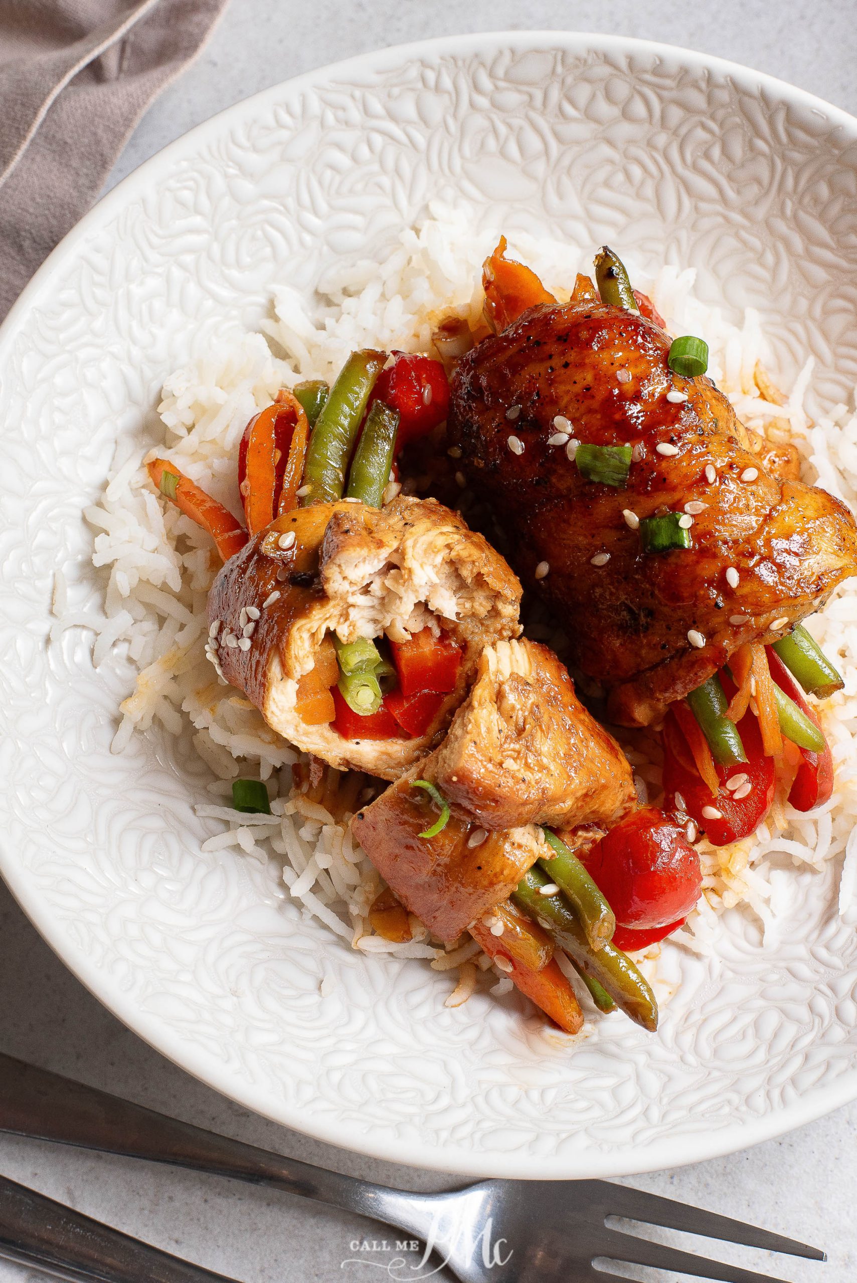 A white plate with chicken and vegetables on it.