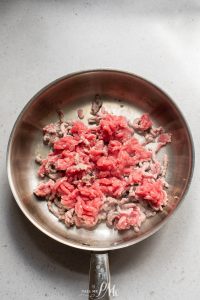 The meat is being cooked in a frying pan.