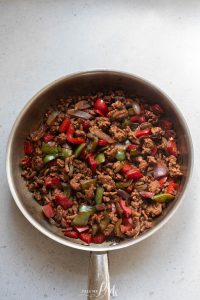 A frying pan filled with meat and peppers.