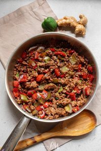 A frying pan filled with meat and vegetables.