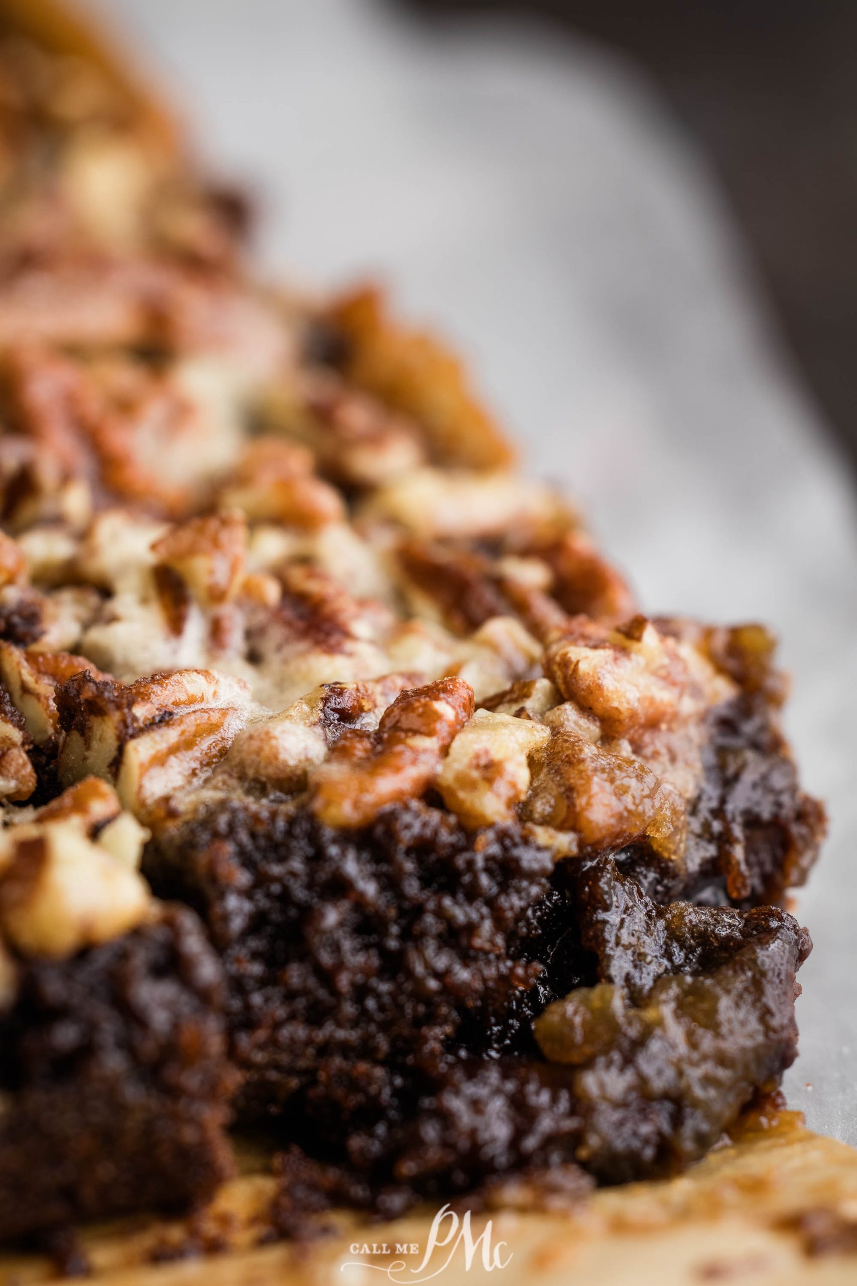 A close up of a brownie with pecans on top.