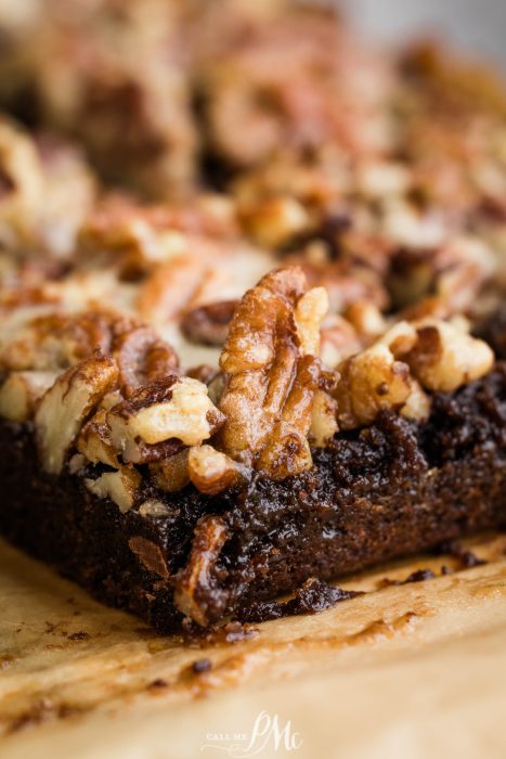 A close up of a brownie with nuts on top.