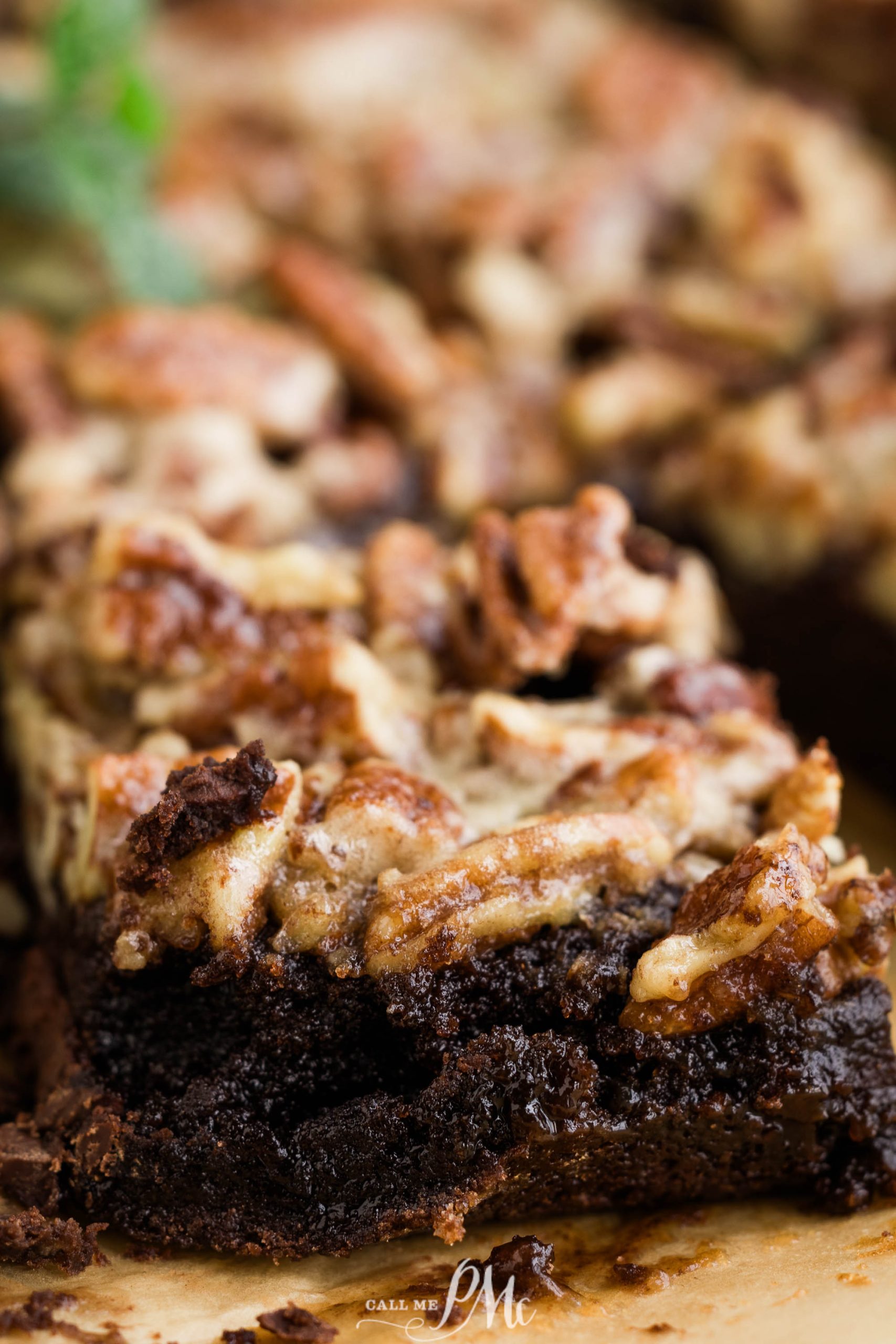 A close up of a brownie with pecans on top.