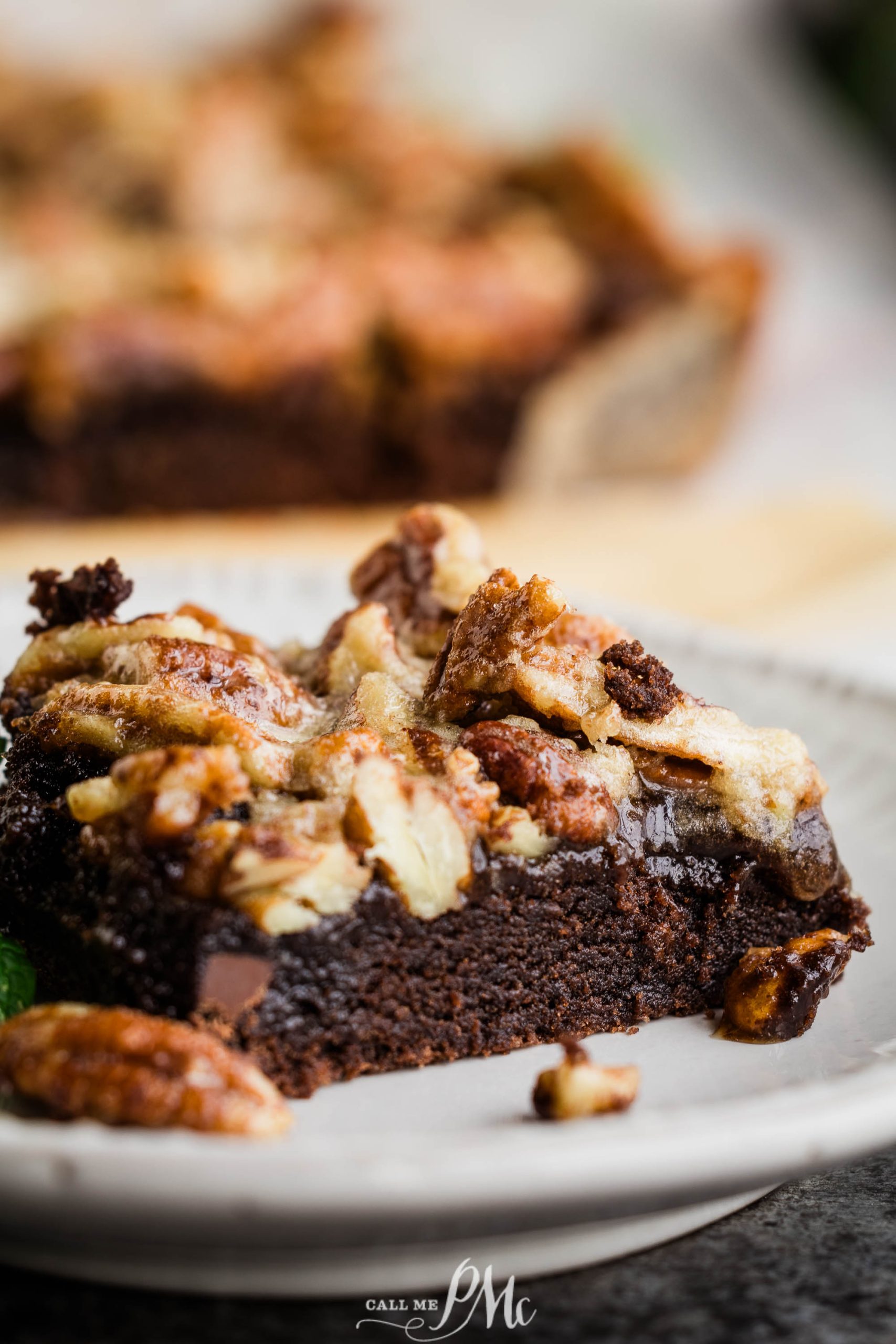 A slice of chocolate brownie with pecans on a plate.