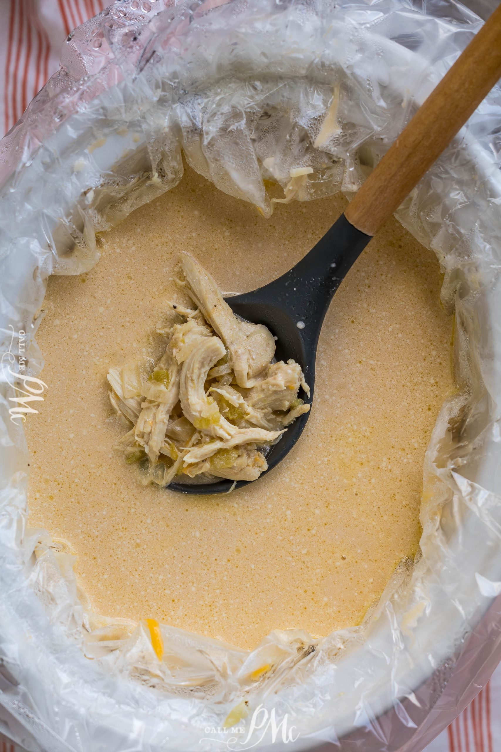 A bowl of chicken soup with a spoon in it.