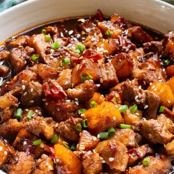 A white bowl filled with Stovetop Pineapple Pork Tenderloin.