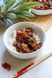A bowl of Stovetop Pineapple Pork Tenderloin stir fry with chopsticks.
