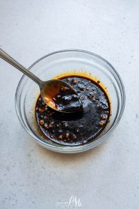 A bowl of sauce with a spoon in it.