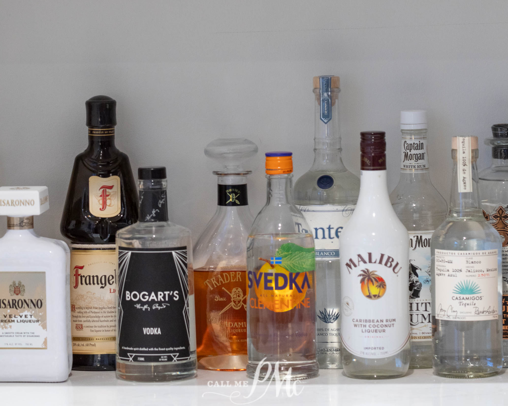 A row of liquor bottles lined up on a shelf. Does alcohol expire?