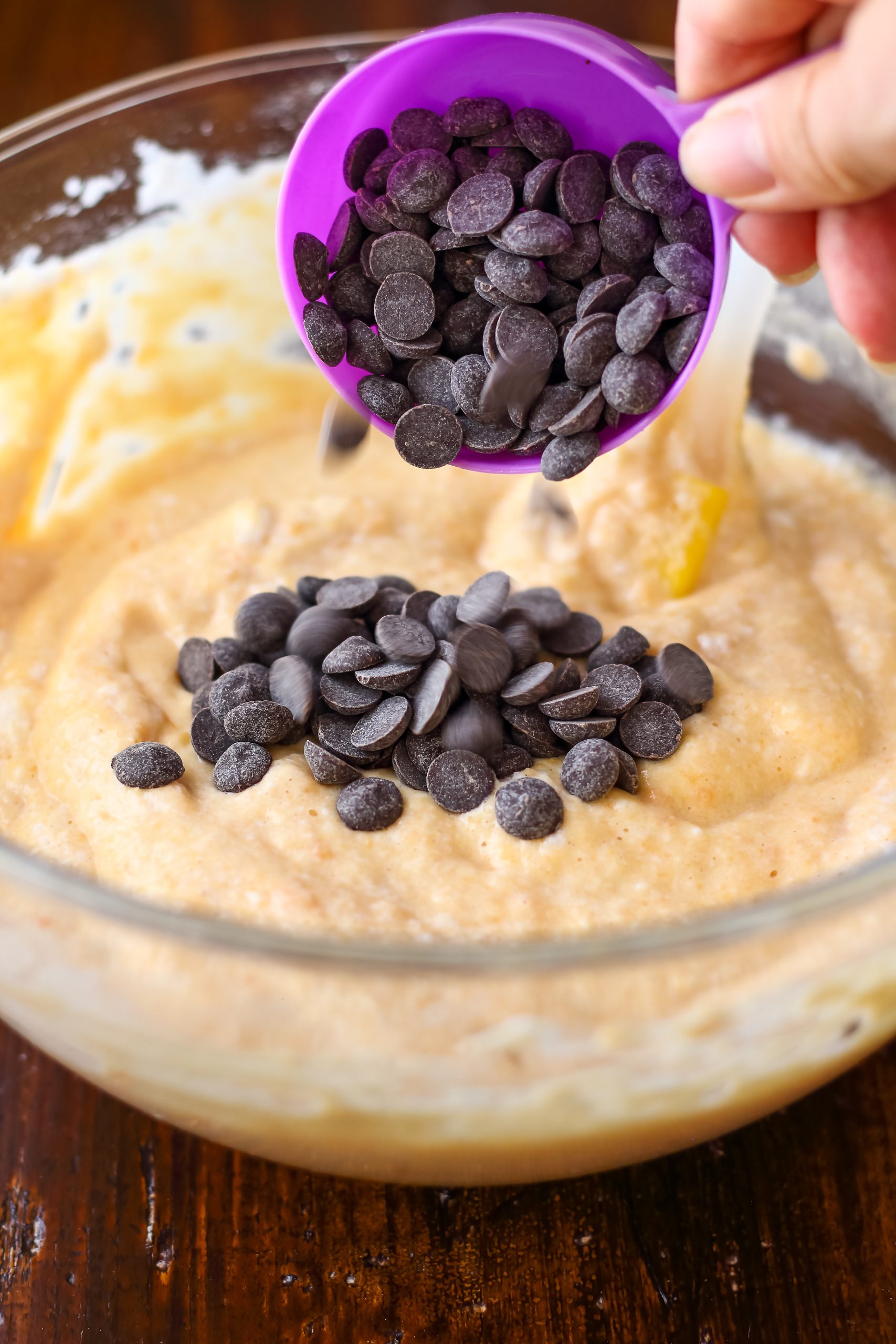 A person pouring chocolate chips into a bowl.