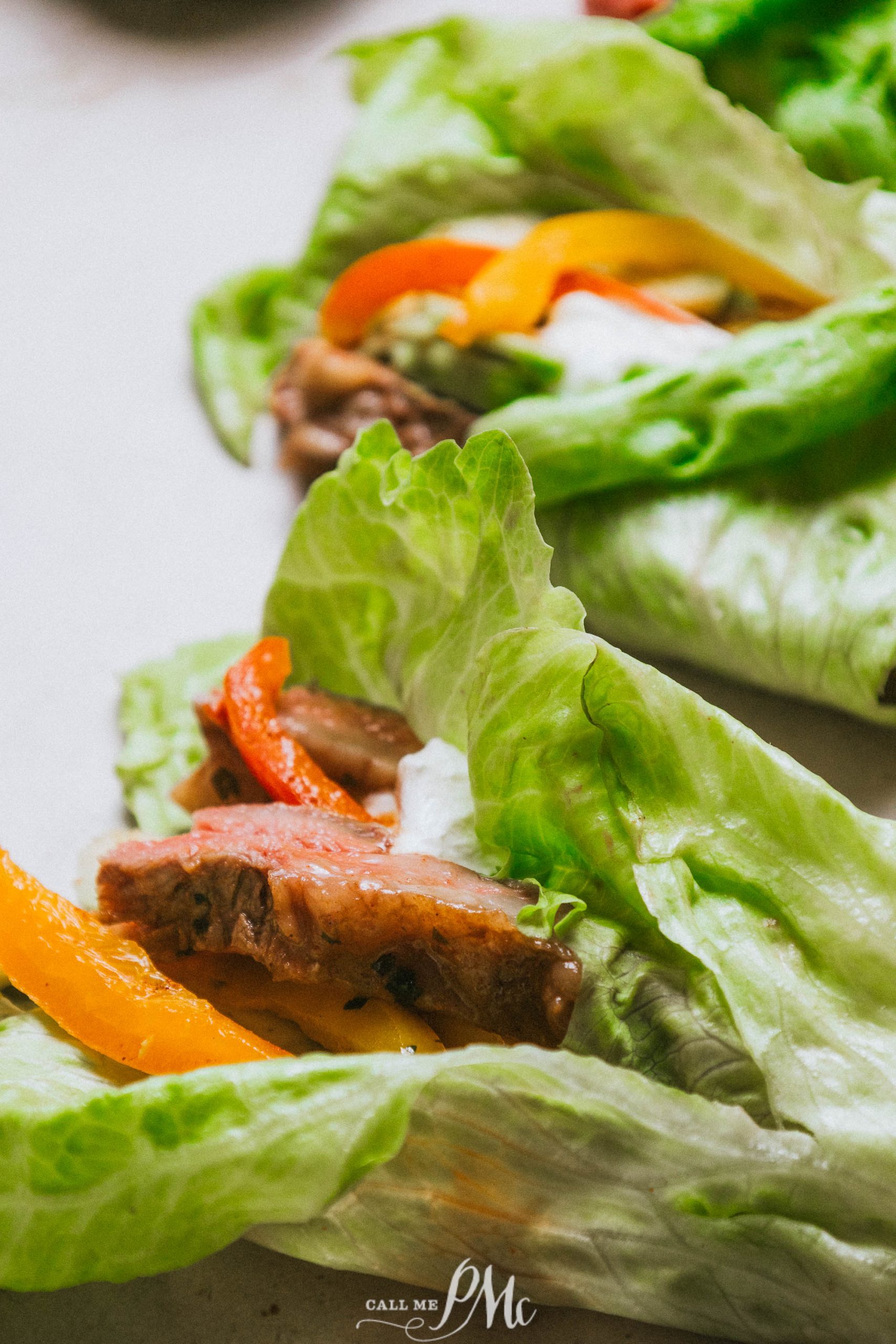 A plate of lettuce wraps with meat and peppers.