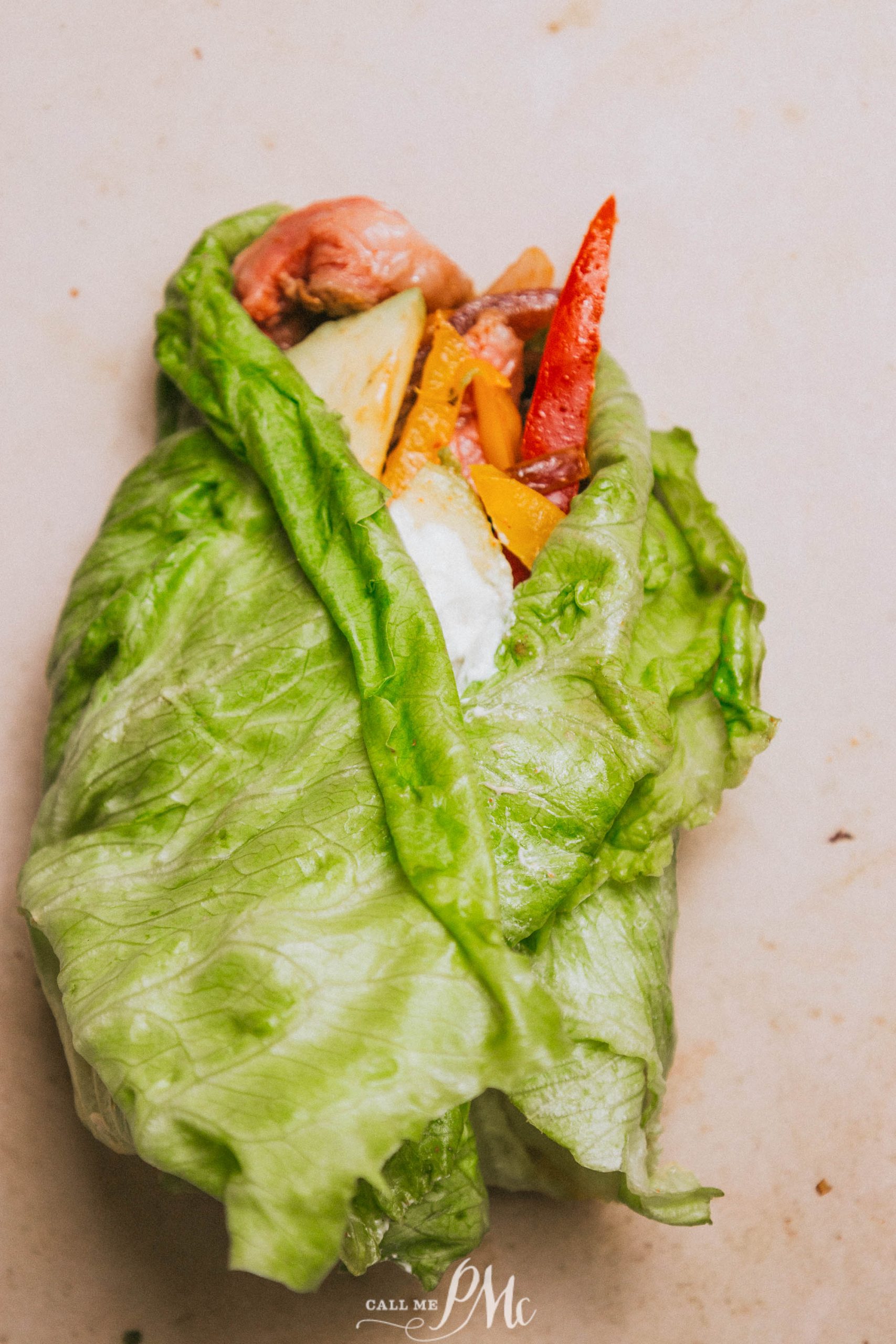 A lettuce wrap filled with vegetables and meat.