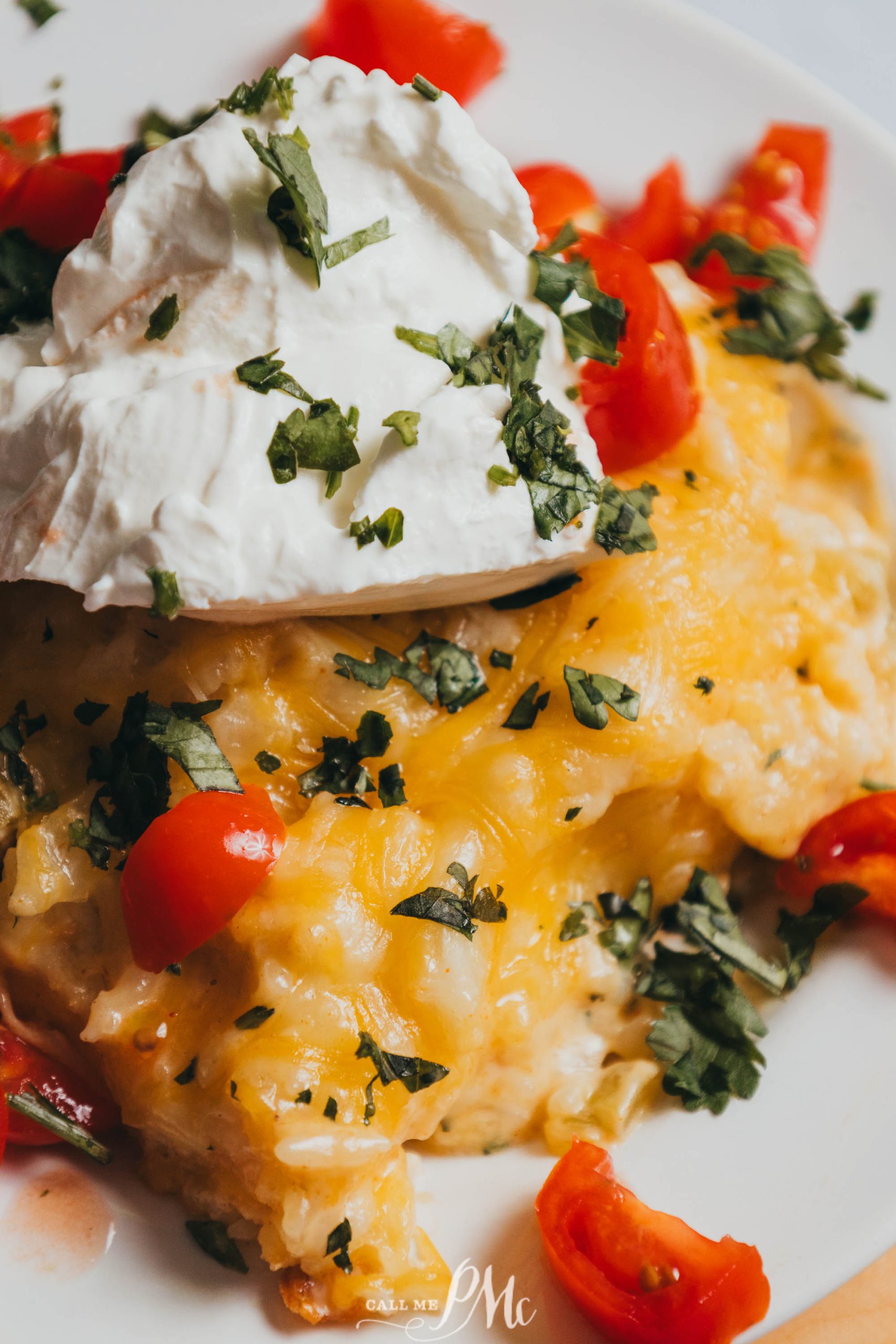 A plate of 30-minute Mexican Chicken Casserole with tomatoes and sour cream.