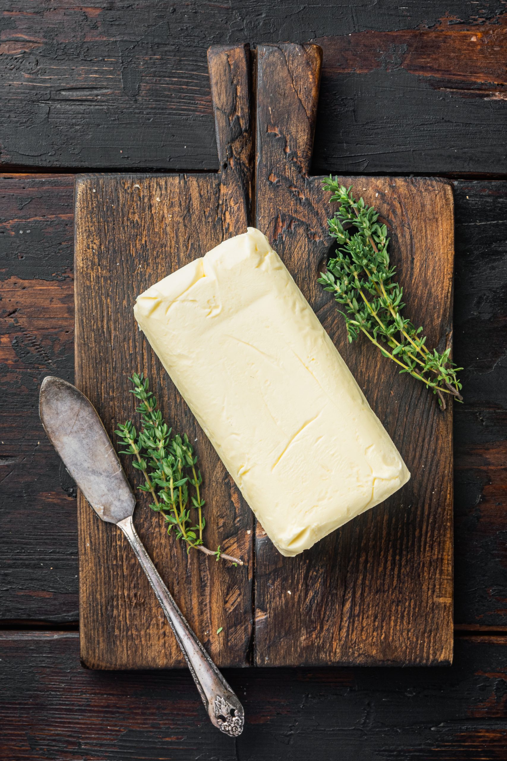 Butter on a wooden cutting board with thyme.