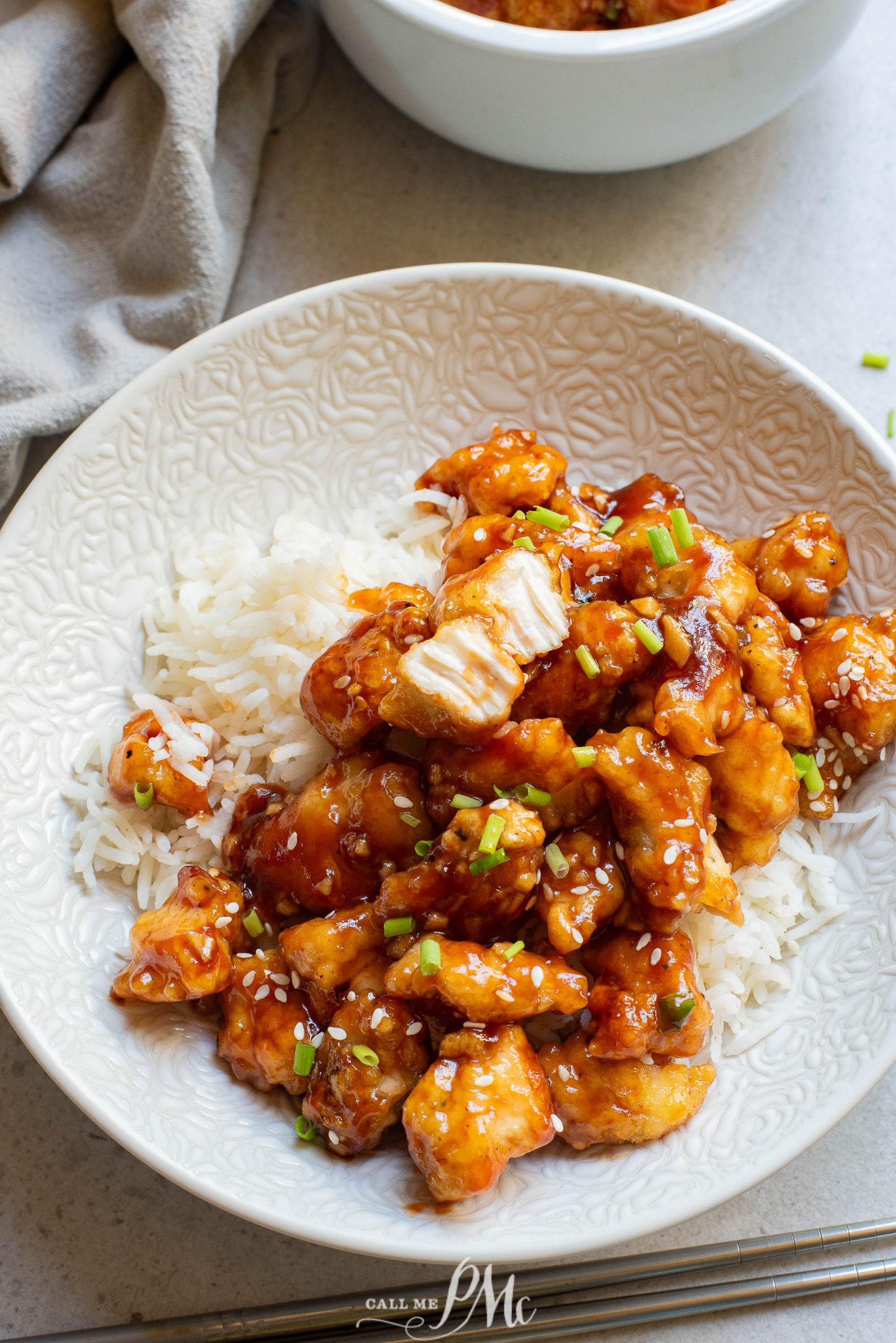 A white plate with chicken and rice on it.