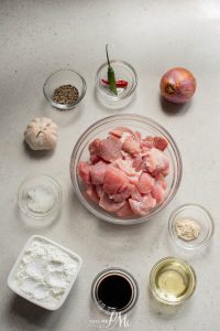 The ingredients for a chicken dish are laid out on a table.