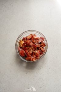 Bacon in a bowl on a white surface.