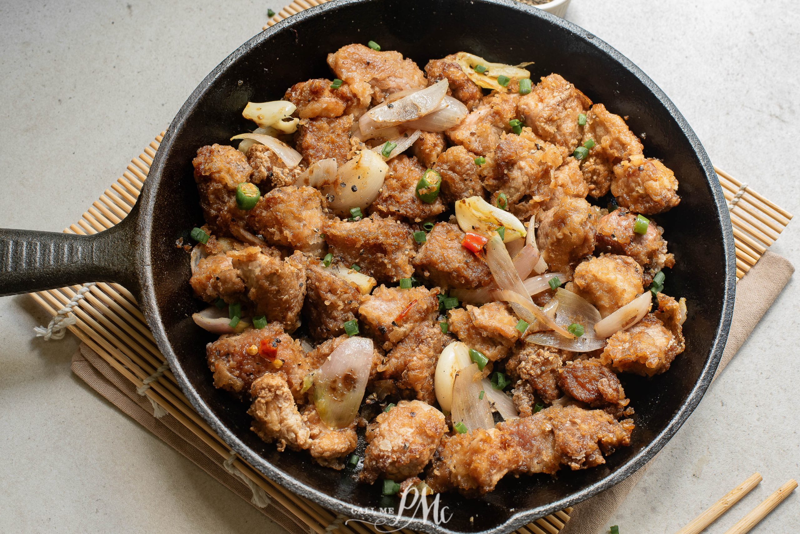 Salt Pepper Pork Chop Bites in a skillet with chopsticks.