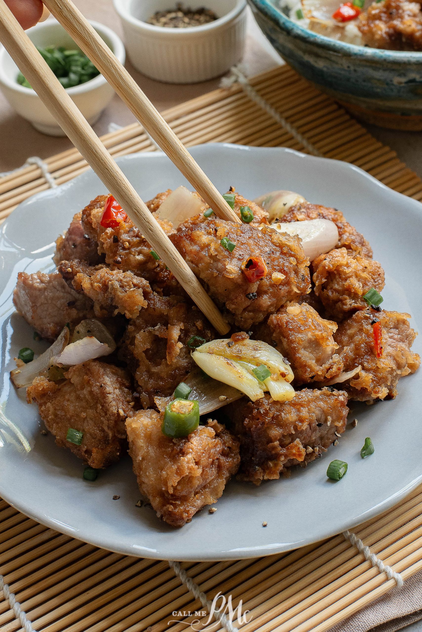 A plate of Salt Pepper Pork Chop Bites with chopsticks on it.