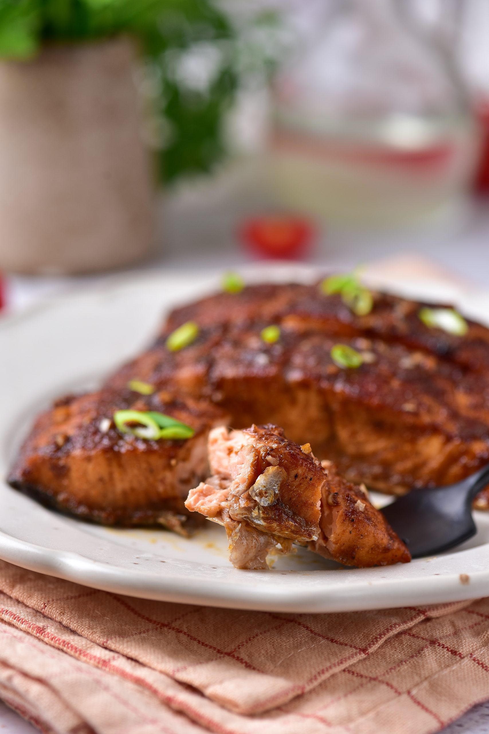 A piece of salmon on a plate with a fork.