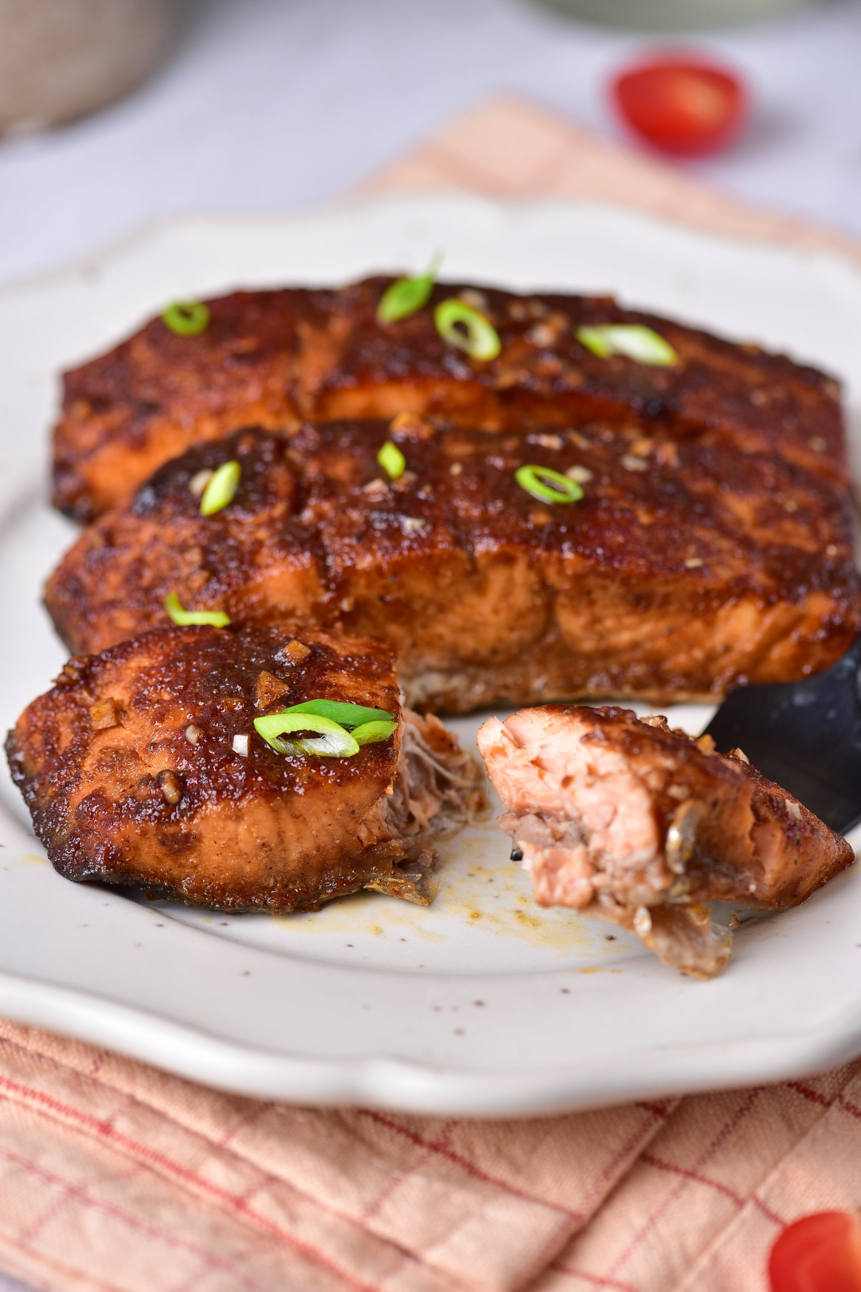 A piece of salmon on a plate with a fork.