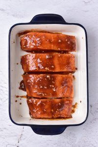 A baking dish with a piece of salmon in it.