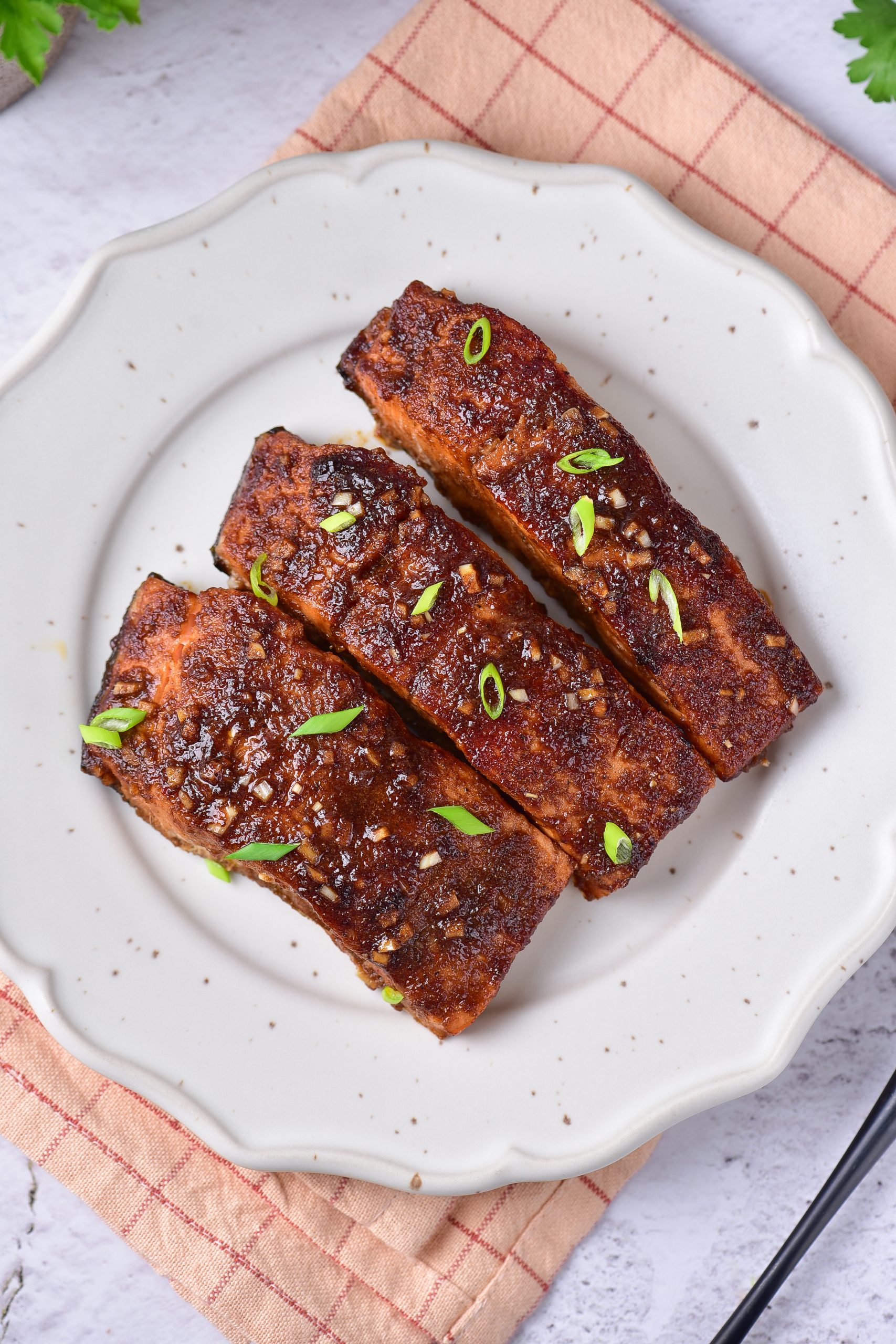 A plate with three pieces of Baked Firecracker Salmonon it.