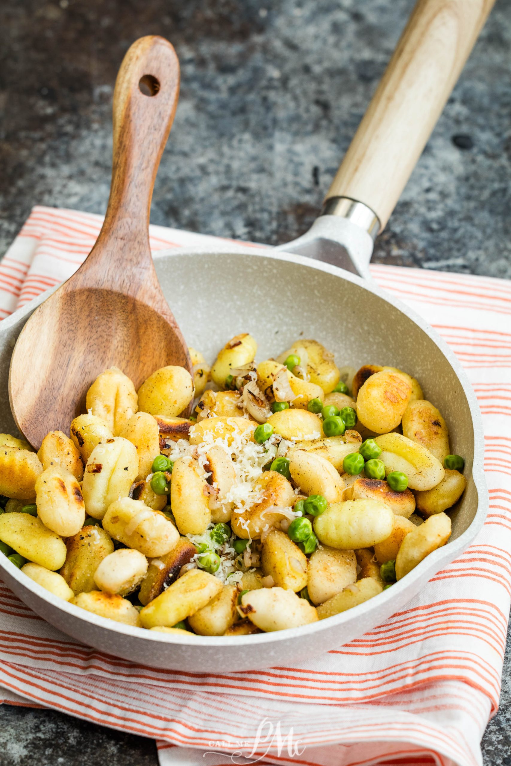 A frying pan filled with mashed potatoes and peas.