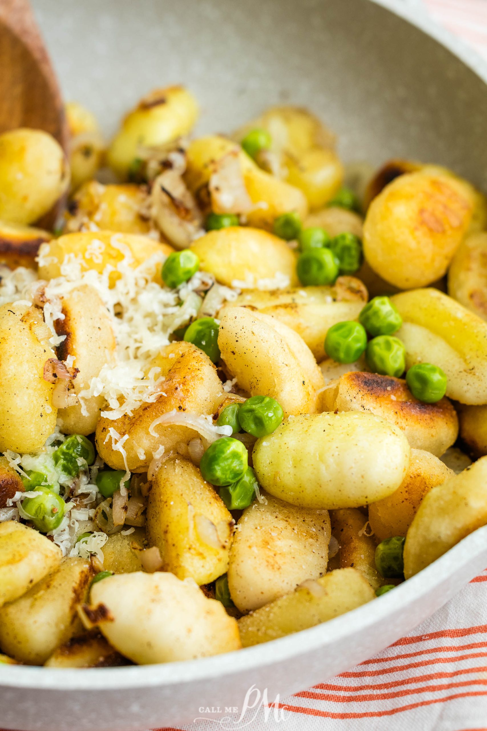 Gnocchi with peas and parmesan in a skillet.