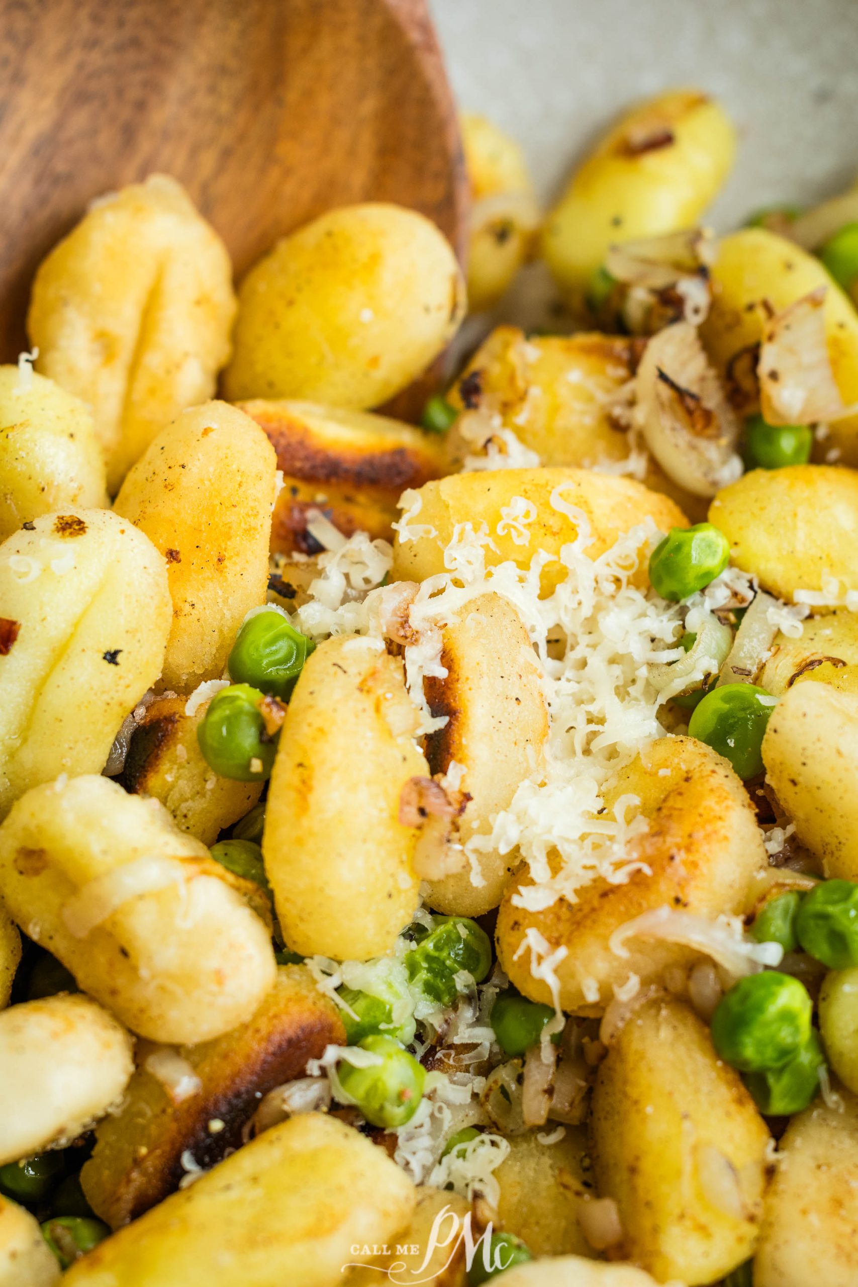 Gnocchi with peas and parmesan in a white bowl.