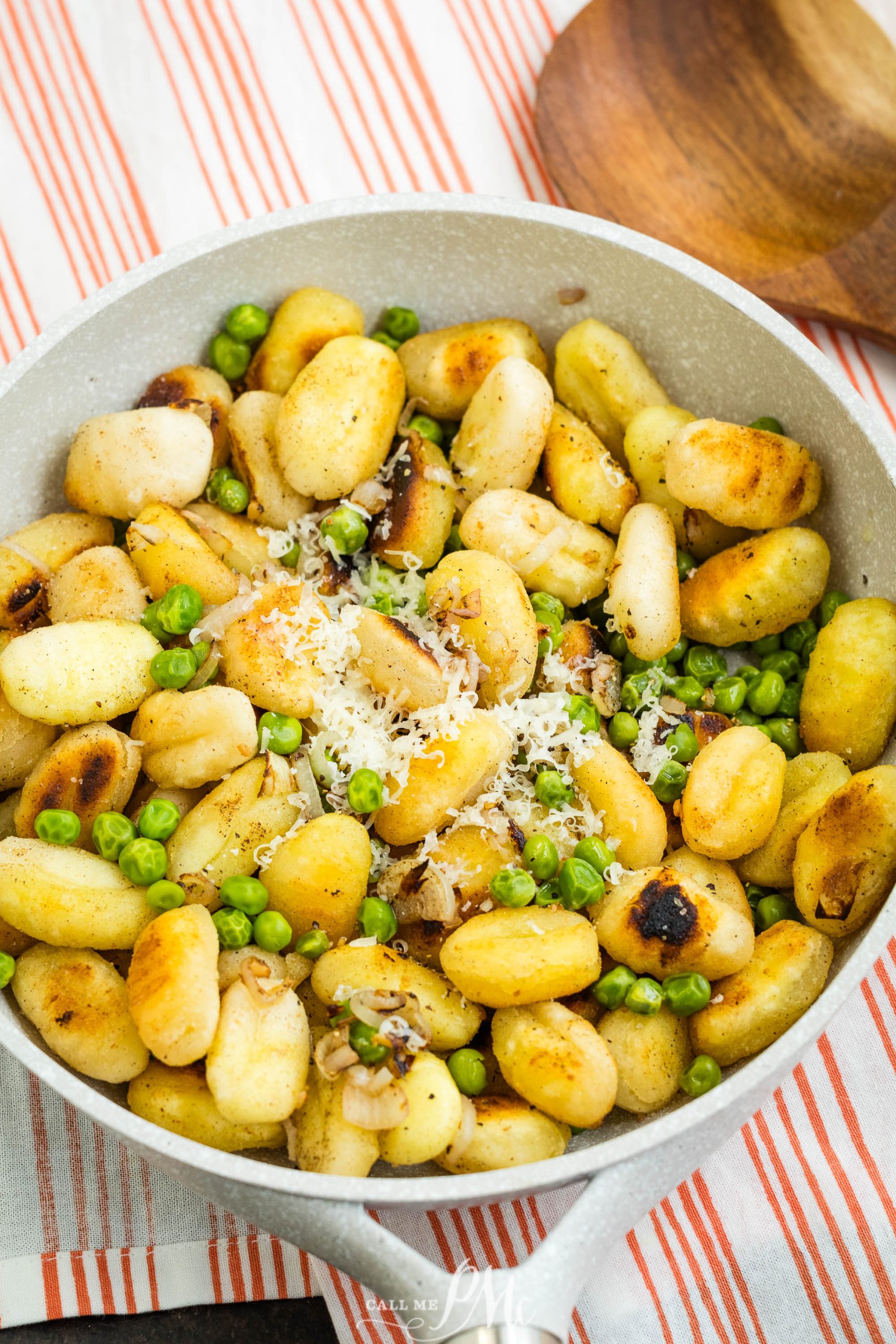 Garlic Herb Butter Gnocchi in a skillet with a wooden spoon.