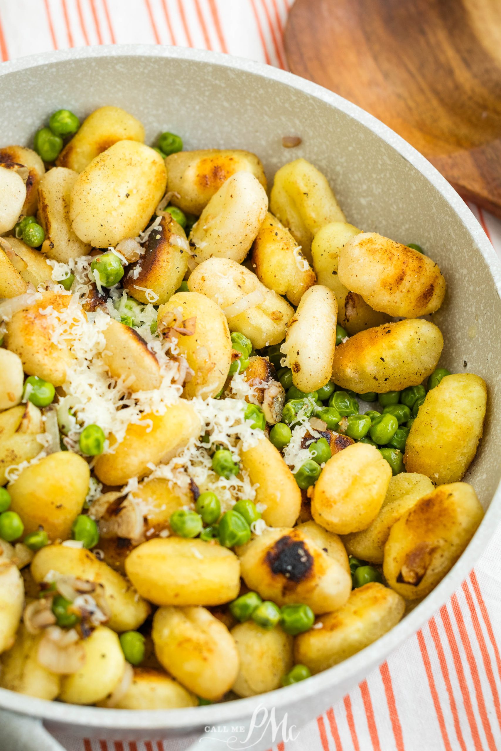 Gnocchi with peas and parmesan in a skillet.